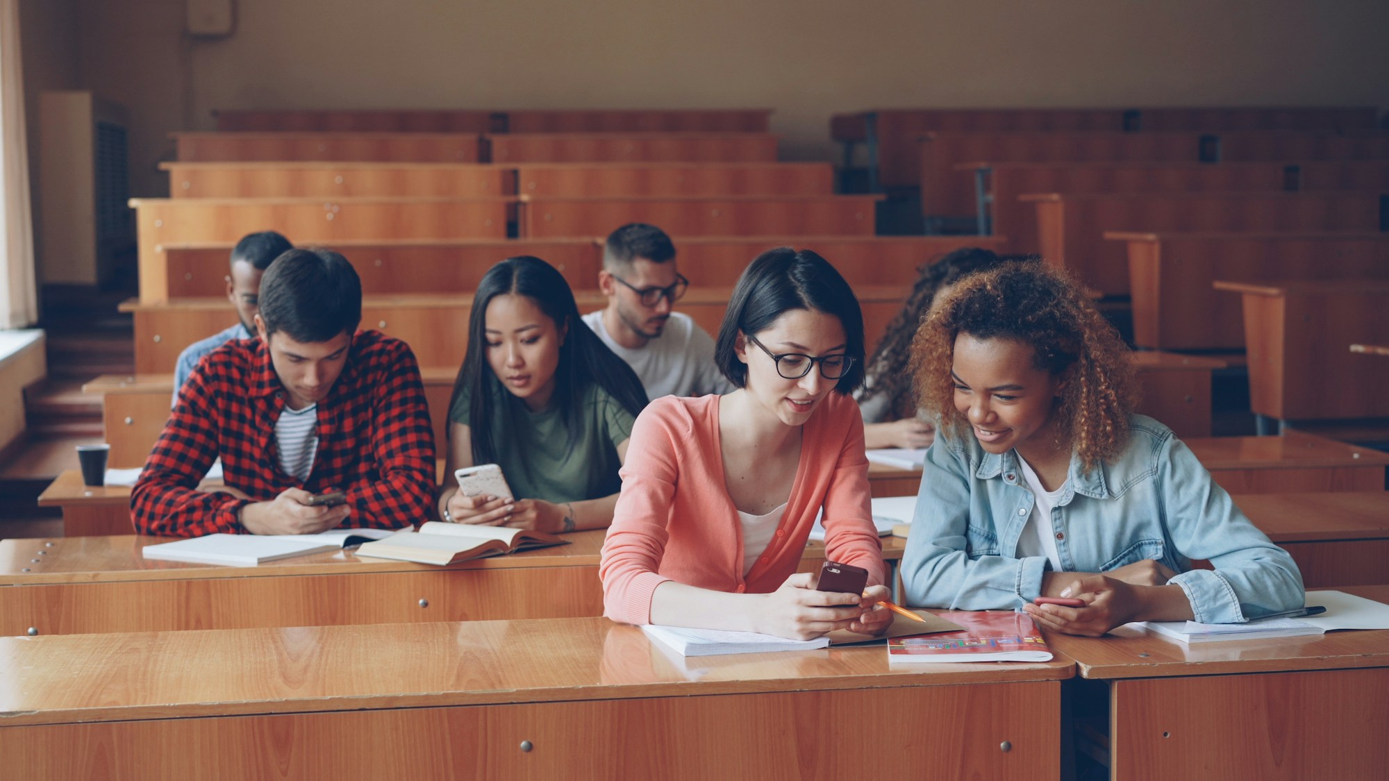 Estudiantes en un aula universitaria neutra, sin nombres ni logotipos visibles
